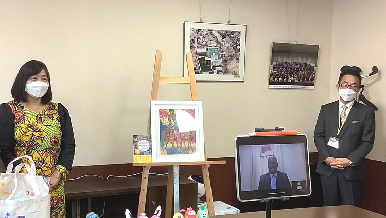 Ambassador Baraka H. Luvanda gave a congratulatory message (online) to mark the 10th anniversary of the event, witnessing are the Principal of the School (right), Artistic Director of Tingatinga Tanzania (left) and students (front - not pictured)
