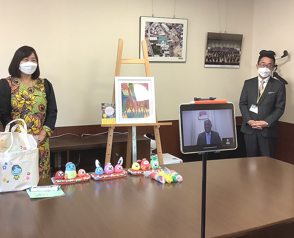 Ambassador Baraka H. Luvanda gave a congratulatory message (online) to mark the 10th anniversary of the event, witnessing are the Principal of the School (right), Artistic Director of Tingatinga Tanzania (left) and students (front - not pictured)