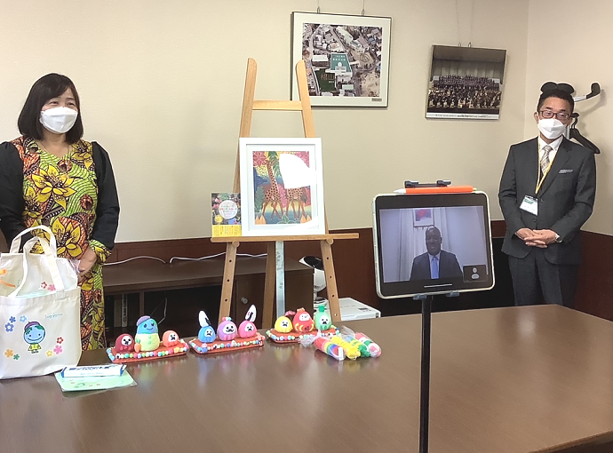 Ambassador Baraka H. Luvanda gave a congratulatory message (online) to mark the 10th anniversary of the event, witnessing are the Principal of the School (right), Artistic Director of Tingatinga Tanzania (left) and students (front - not pictured)